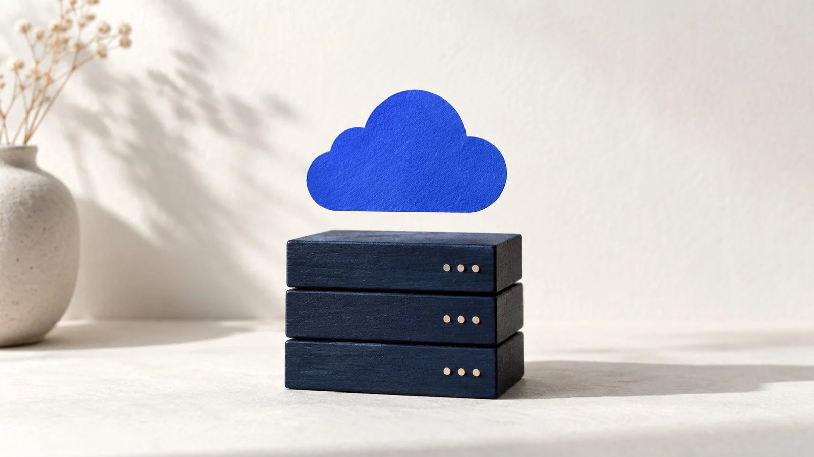 Wooden blocks shaped like servers under a blue paper cloud.
